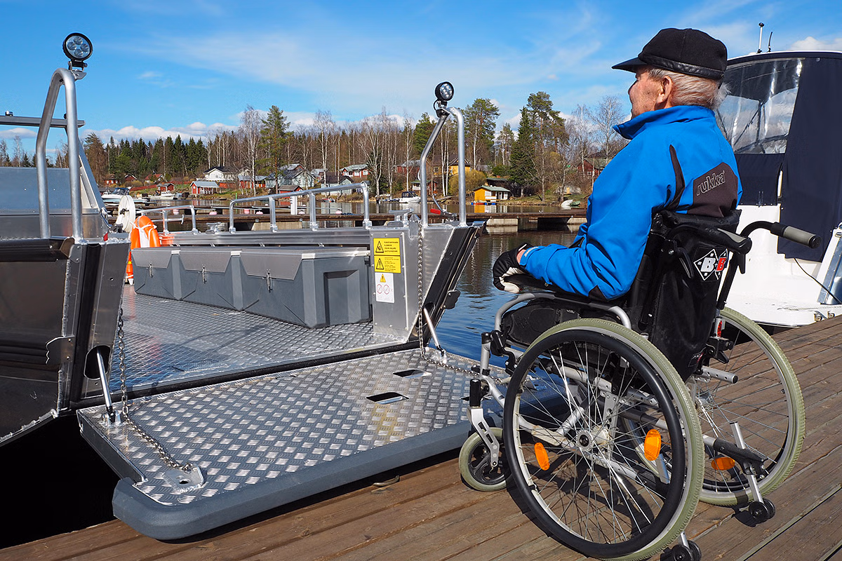 Person in wheelchair entering an accessible boat in Oravi Harbour