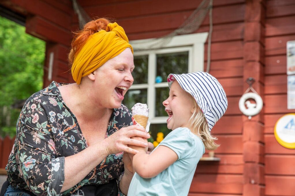 Nainen ja lapsi syömässä jäätelöä Linnansaaren kahvilan terassilla